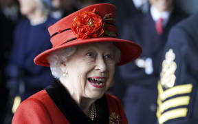 Britain's Queen Elizabeth II reacts as she meets military personnel during her visit to the aircraft carrier HMS Queen Elizabeth in Portsmouth, southern England on May 22, 2021.