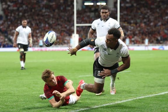 Fiji's full back Sireli Maqala (right) passes the ball ahead of Portugal's fly-half Jeronimo Portela (left) during the France 2023 Rugby World Cup Pool C match between Fiji and Portugal at the Stade de Toulouse in Toulouse, southwestern France on October 8, 2023.