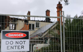 The burnt City Garden Lodge in Parnell, Auckland, with a 'do not enter' sign on the fence outside.