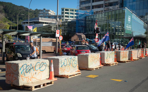 Convoy anti-mandate protesters behind a perimeter set up by police.