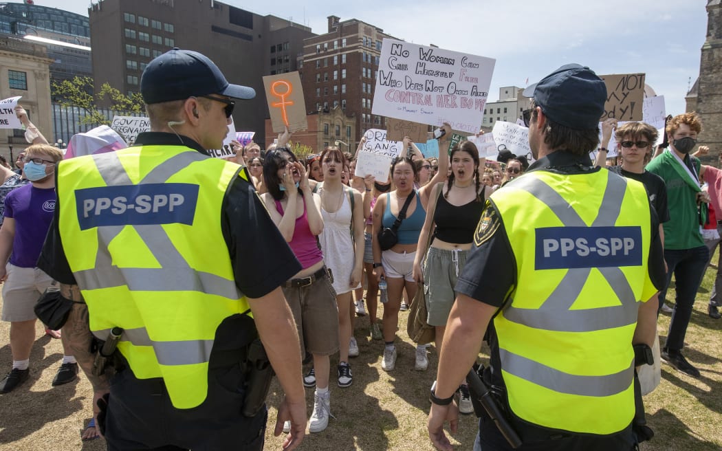 Parliamentary Protective Service officers keep pro-choice protesters separate from the pro-life protesters during the National March for Lifein Ottawa, Ontario, on May 12, 2022. - The protest comes amid a political firestorm in the United States ignited by a leaked draft opinion that showed the Supreme Court's conservative majority preparing to overturn Roe v. Wade, a landmark 1973 ruling guaranteeing abortion access nationwide. (Photo by Lars Hagberg / AFP)