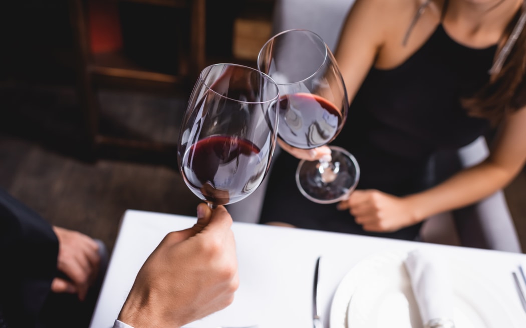 Couple clinking wine glasses.