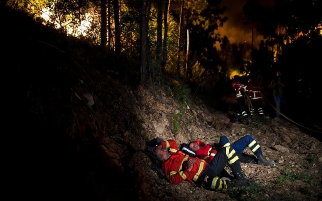 Firefighters rest during a wildfire at Penela, Coimbra, central Portugal.