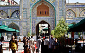 Pedestrians walk past a Shi-te shrine in Kadhimiya, Baghdad