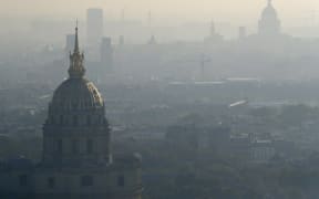 A photo taken on October 12, 2016 shows the domes of Les Invalides (L) and the Pantheon (R) in Paris seen through a veil of smog.
