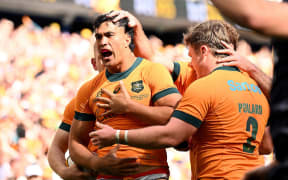 Joseph-Aukuso Suaalii of Australia celebrates with teammates after scoring a try.