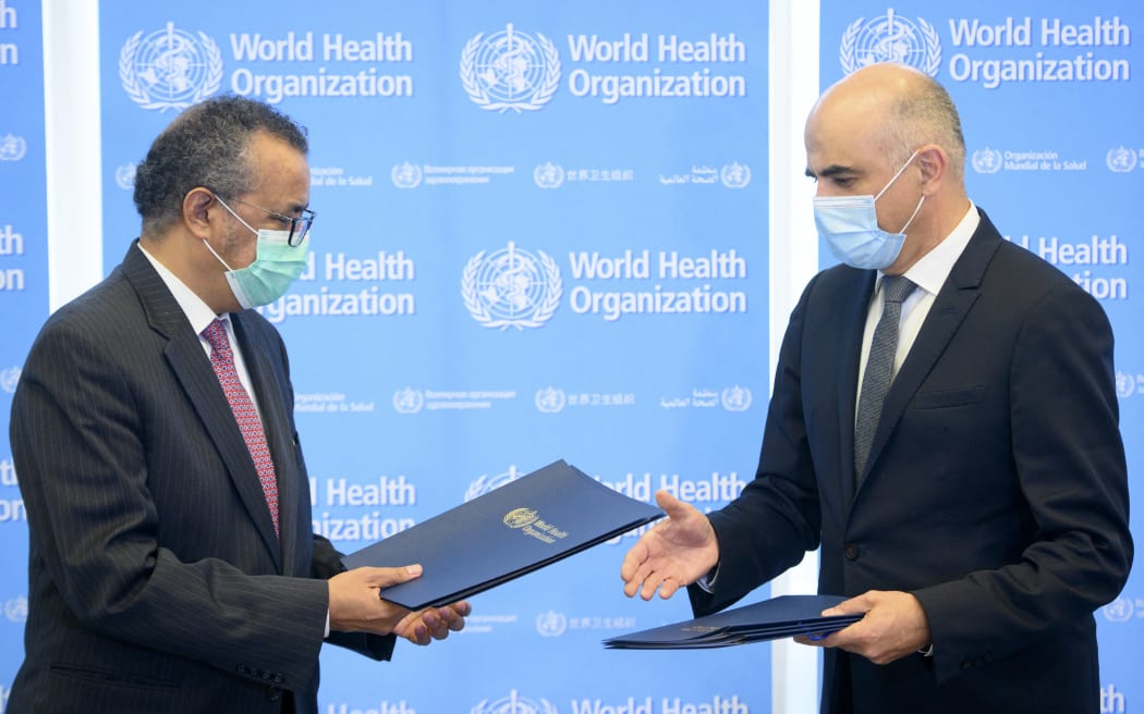 Swiss Interior and Health Minister Alain Berset (R) and the Director General of the World Health Organization (WHO) Tedros Adhanom Ghebreyesus (L) exchange documents during a bilateral meeting after signing the BioHub Initiative with a global Covid-19 pathogen repository in Spiez Laboratory on the sideline of the opening of the 74th World Health Assembly at the WHO headquarters in Geneva on 24 May, 2021.