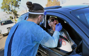 A man has a swab sample taken during testing for the COVID-19 coronavirus at a drive through pop-up venue in Melbourne on July 1, 2020.
