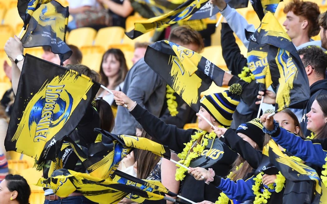 Hurricanes rugby fans celebrate a try.