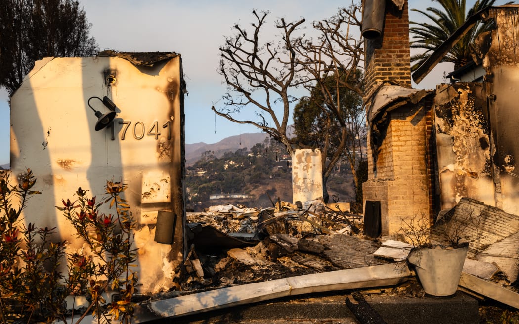 The remnants of a house, destroyed in the Palisades Fire, are seen in the Pacific Palisades neighborhood of Los Angeles, California, on January 10, 2025. Massive wildfires that engulfed whole neighborhoods and displaced thousands in Los Angeles have killed at least 10 people, authorities said, as California's National Guard soldiers readied to hit the streets to help quell disorder.
News of the growing toll, announced late Thursday January 9 by the Los Angeles County Medical Examiner, came as swaths of the United States' second-largest city lay in ruins. (Photo by Zoë Meyers / AFP)