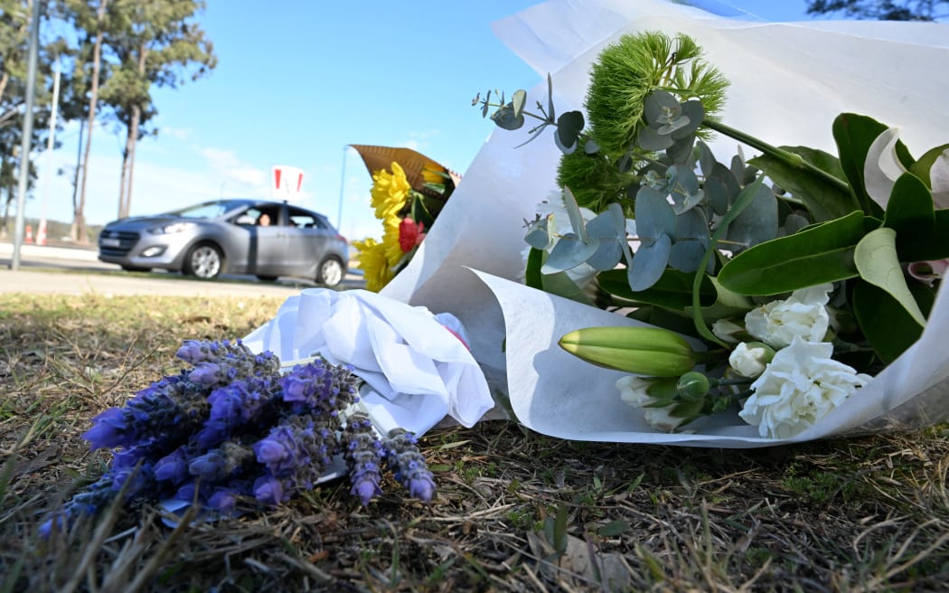 Flowers are left by the road some 500 meters from the site of a bus crash, where 10 people from a wedding party were killed, in Cessnock, in Australia's Hunter wine region north of Sydney on June 12, 2023. A wedding party bus crash killed 10 people in Australia's Hunter wine region north of Sydney, police said on June 12, announcing the arrest of the 58-year-old driver. (Photo by Saeed KHAN / AFP)