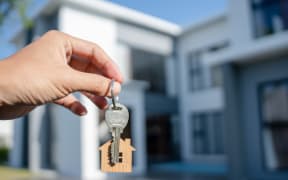 Selling home ,Landlord and New home. The house key for unlocking a new house is plugged into the door. Mortgage, rent, buy, sell, move home concept