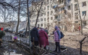 This handout photograph taken and released by the State Emergency Service of Ukraine on March 10, 2026 shows local residents standing outside the buildings at the site of an air attack in Sloviansk, amid the Russian invasion of Ukraine. (Photo by Handout / STATE EMERGENSY SERVICE OF UKRAINE / AFP) / RESTRICTED TO EDITORIAL USE - MANDATORY CREDIT "AFP PHOTO / STATE EMERGENCY SERVICE OF UKRAINE" - NO MARKETING NO ADVERTISING CAMPAIGNS - DISTRIBUTED AS A SERVICE TO CLIENTS