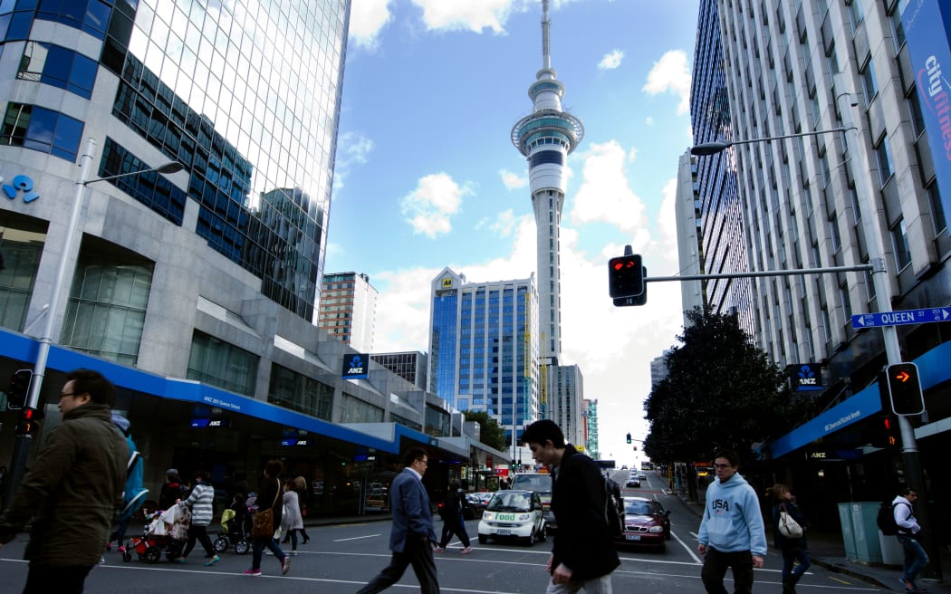 AUCKLAND, NZ - MAY 29:Traffic on Queen street with the Skytower in the background on May 29 2013.It's a major commercial thoroughfare in the Auckland CBD, New Zealand's main population center.