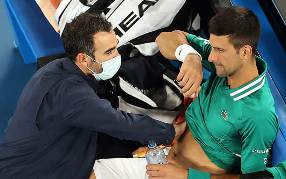 Serbia's Novak Djokovic gets medical treatment while playing against Taylor Fritz of the US during their men's singles match on day five of the Australian Open tennis tournament in Melbourne on February 12, 2021.