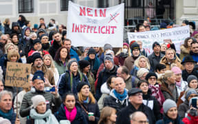A demonstrator holds a placard reading 'No to compulsory vaccination' during an anti-vaccination protest at the Ballhausplatz in Vienna, Austria, on November 14, 2021.