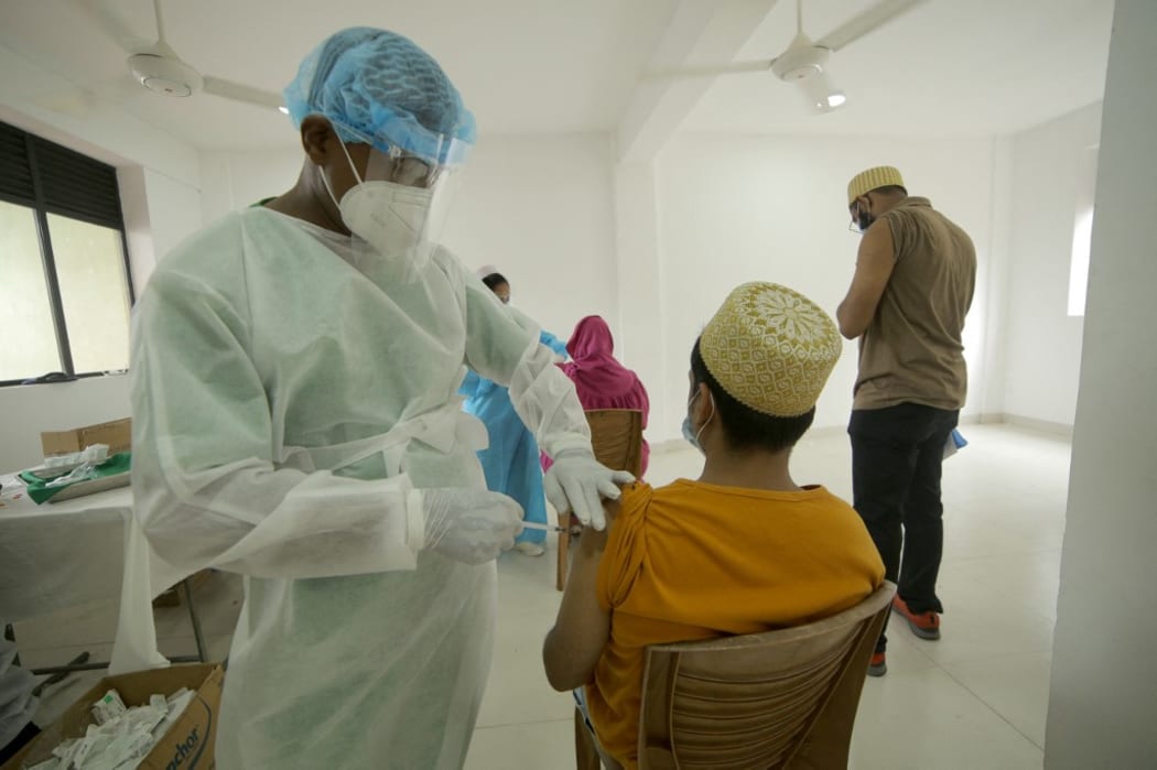 A Sri Lankan health worker  wearing  protective gear administers a jab of  Chinese-made Sinopharm vaccine  against Covid-19 virus  in Colombo, Sri Lanka on 14 May 2021..