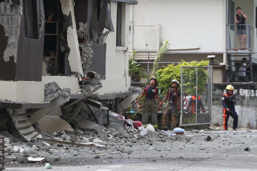 Rescuers at a damaged building after a 6.8 earthquake in Davao.