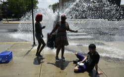 People cool off with water from an open fire hydrant during a heat wave on the West Side of Chicago, Illinois, on July 2, 2026. Blistering temperatures and humidity gripped swaths of the United States on July 1, with the worst yet to come for the densely populated East Coast as the nation co-hosts the World Cup and prepares to celebrate its 250th birthday. “Heat dome” conditions — in which high-pressure systems trap warm air like the lid on a pot — persisted over the Midwest and South and were moving east, with some 46 million people under heat alerts.
