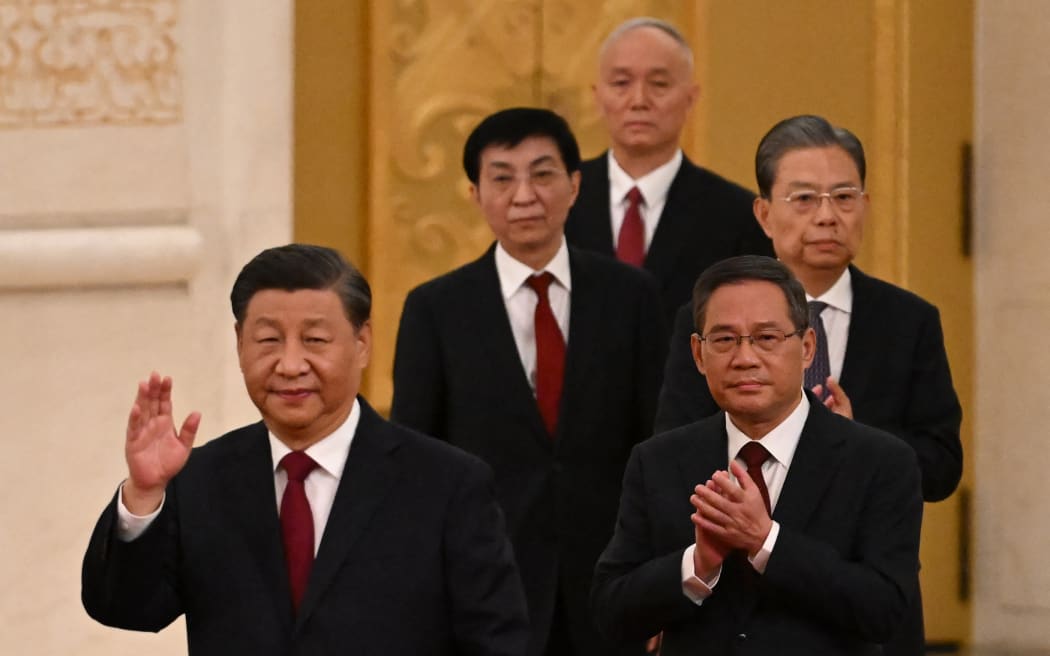 China's President Xi Jinping (left) walks with members of the Chinese Communist Party's new Politburo Standing Committee, the nation's top decision-making body, including Li Qiang (front right), as they meet the media in the Great Hall of the People in Beijing on October 23, 2022.