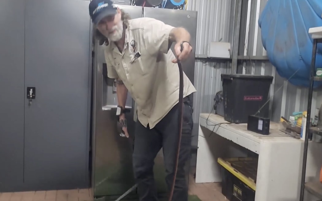 Adelaide Hills snake catcher Simon Hempel retrieves the red-bellied black snake.