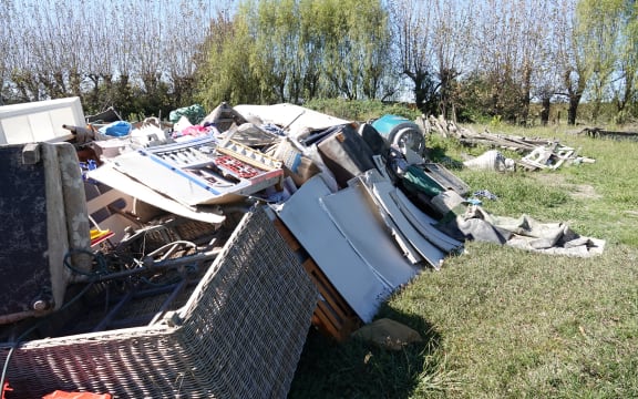 The Hadden family's flood-damaged belongings are lying on the grass in front of their ruined house.