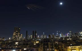 Rocket trails are seen in the sky above the Israeli coastal city of Tel Aviv on March 5, 2026. The United Nations rights chief on March 6 called for cool heads to prevail in the Middle East and urged the warring sides to pull back and "give peace a chance". The crisis sparked in the Middle East a week ago by the barrage of US and Israeli strikes on Iran "has been spreading like wildfire", Volker Turk told reporters in Geneva.