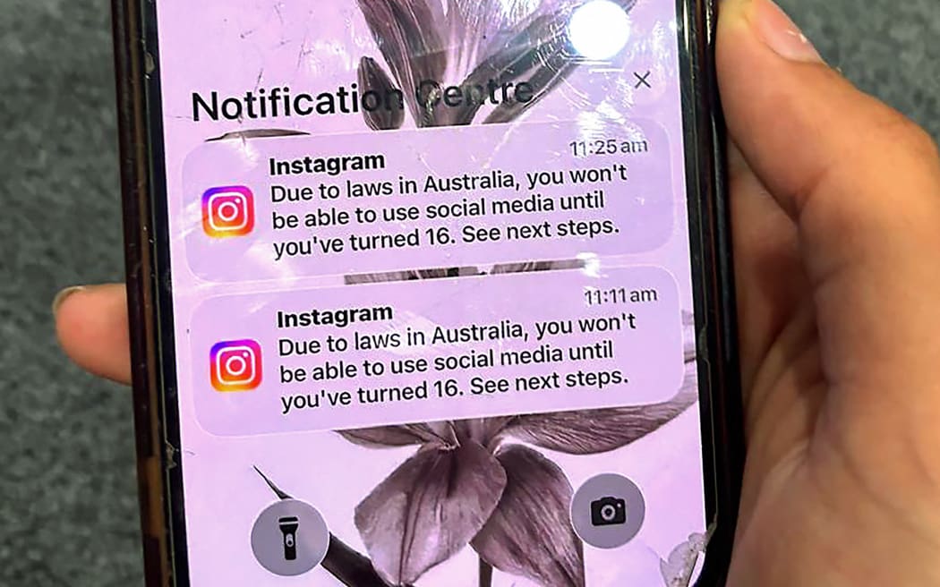 A teenager holds a mobile phone displaying a message from social media platform Instagram after the account was locked for age verification in Sydney on 9 December, 2025.