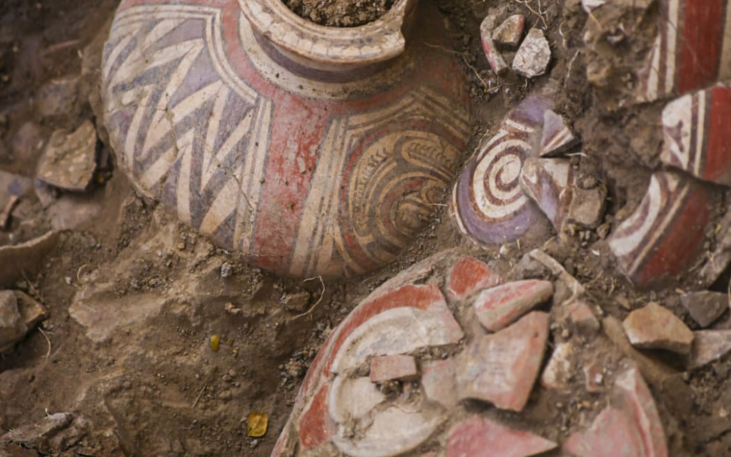 This handout picture released by Panama’s Ministry of Culture shows an archaeologist working inside a pre-Hispanic tomb approximately 1,200 years old, discovered at the El Cano Archaeological Park in Cocle, Panama, on February 20, 2026. The tomb contained the remains of a high-ranking lord of the Cocle culture, along with abundant gold and ceramic grave goods. (Photo by Handout / Panama / AFP) / RESTRICTED TO EDITORIAL USE - MANDATORY CREDIT "AFP PHOTO /  PANAMA’S MINISTRY OF CULTURE" - HANDOUT - NO MARKETING NO ADVERTISING CAMPAIGNS - DISTRIBUTED AS A SERVICE TO CLIENTS