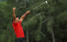 Tiger Woods celebrates after sinking his putt on the 18th green to win during the final round of the Masters at Augusta National Golf Club on April 14, 2019 in Augusta, Georgia.