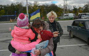 A Ukrainian woman and her children are welcomed by a relative after they were able to leave from Russian occupied territory of Kherson, in Zaporizhzhia, on 21 October, 2022, amid Russia's invasion on Ukraine.
