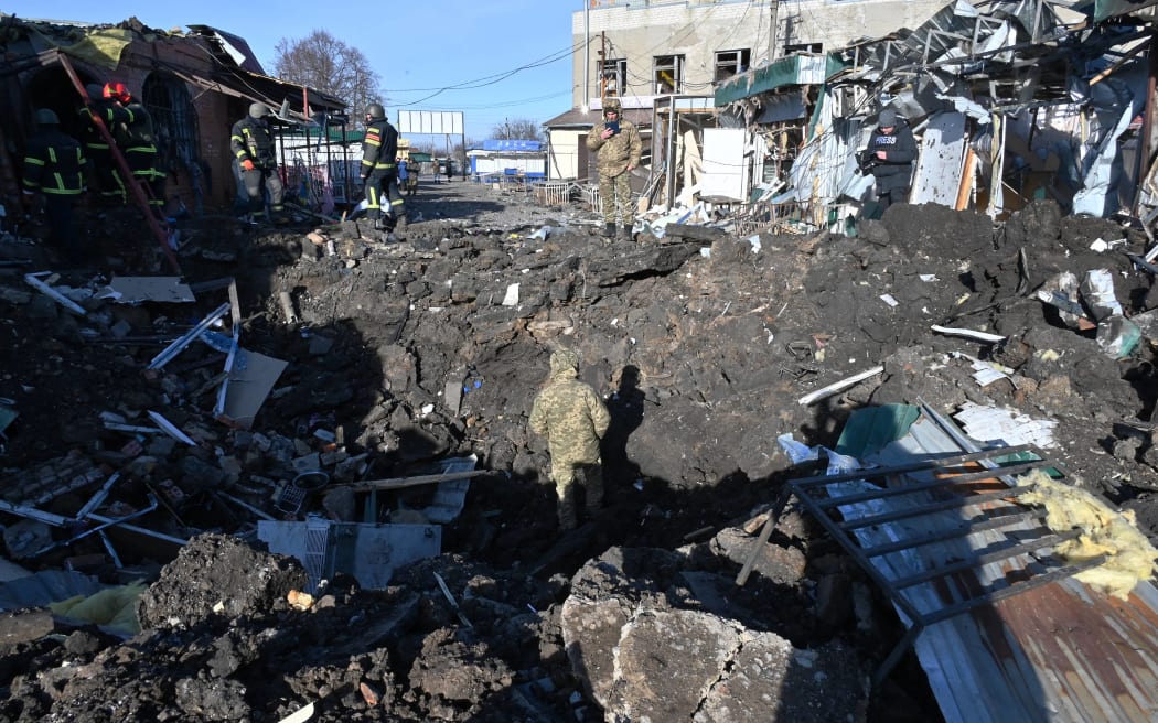 Ukrainian rescuers work on the site following a Russian missile strike on a local market in Shevchenkove village, Kharkiv region.