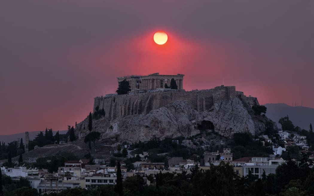 Smoke rises over the Acropolis Hill and the Parthenon from a wildfire that is burning at the western suburbs of the city of Athens, on August 22, 2023 (Photo by Andrea Bonetti / SOOC / SOOC via AFP)
