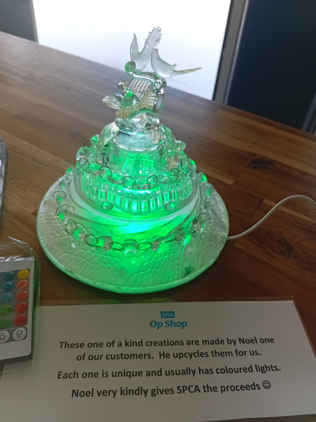 Picture depict a glass ornament with a green light attached inside.