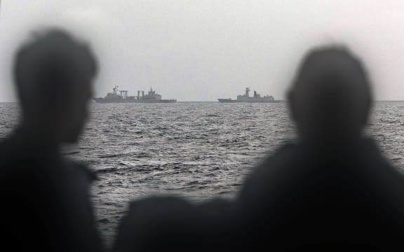 This handout photo taken on February 13, 2025 and released by The Australian Defence Force shows sailors onboard the Royal Australian Navy ship HMAS Arunta looking at the People's Liberation Army-Navy (PLA-N) Fuchi-class replenishment vessel and Weishanhu Jiangkai-class frigate Hengyang in the Tasman Sea. Australia's foreign minister voiced concern on February 21 over live fire drills conducted by three Chinese warships sailing off the country's east coast. (Photo by Handout / AUSTRALIAN DEFENCE FORCE / AFP) / RESTRICTED TO EDITORIAL USE - MANDATORY CREDIT "AFP PHOTO /  AUSTRALIAN DEFENCE FORCE" - NO MARKETING NO ADVERTISING CAMPAIGNS - DISTRIBUTED AS A SERVICE TO CLIENTS