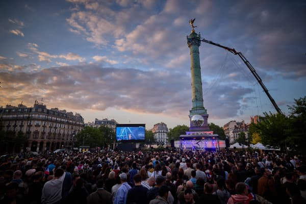 People gather at a fan zone on Place de la Bastille to watch a broadcast of the grand final of the Eurovision Song Contest 2025, which takes place in Basel, Switzerland, in Paris on May 17, 2025.