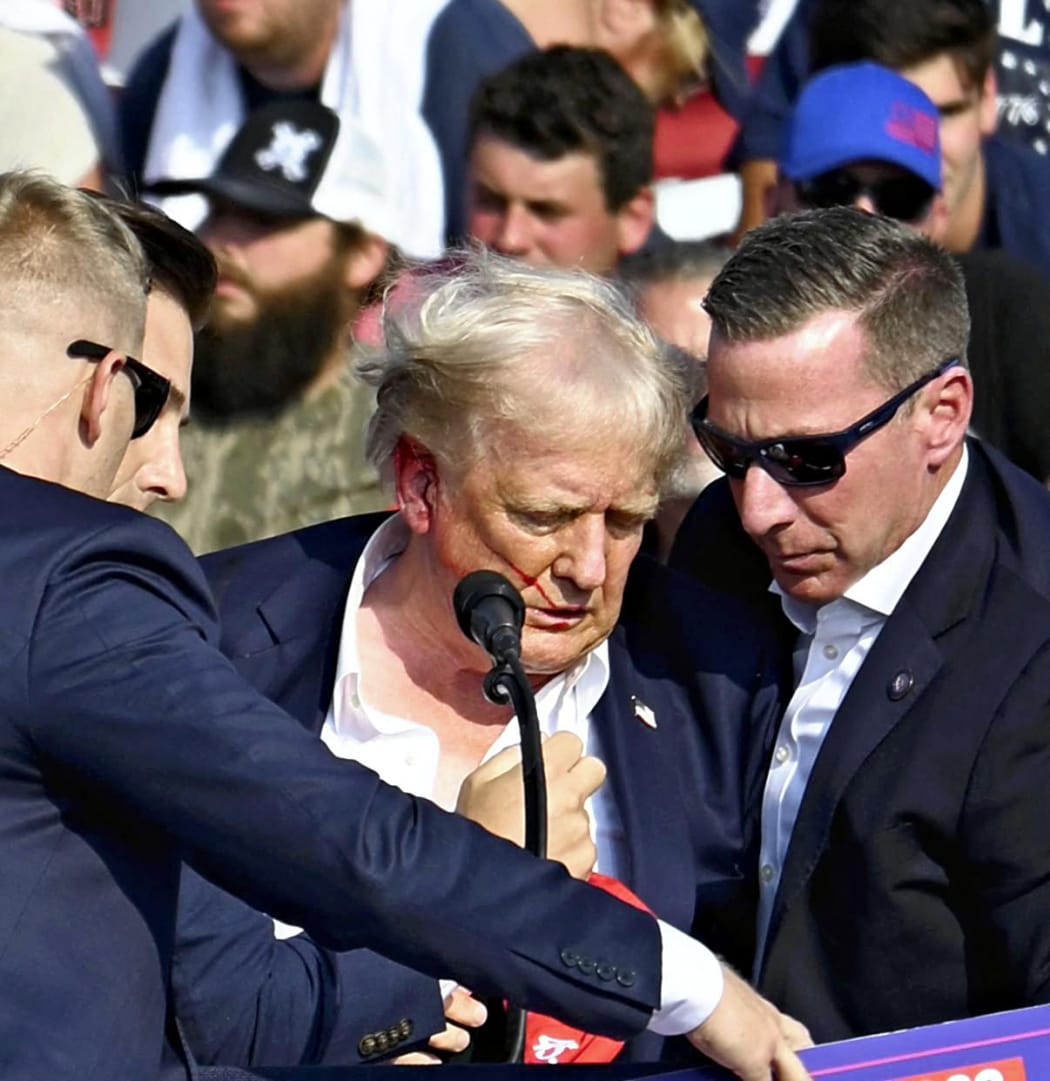 U. S. Republican presidential candidate former President Donald is surrounded by U.S. Secret Service agents in Butler, Pennsylvania on July 13, 2024. The former president suffered a gunshot wound to his ear after a suspect fired gunshots at his Pennsylvania rally and he survived the assassination attempt. According to the law official, the suspected shooter was killed by the Secret Service. ( The Yomiuri Shimbun ) (Photo by Takayuki Fuchigami / Yomiuri / The Yomiuri Shimbun via AFP)