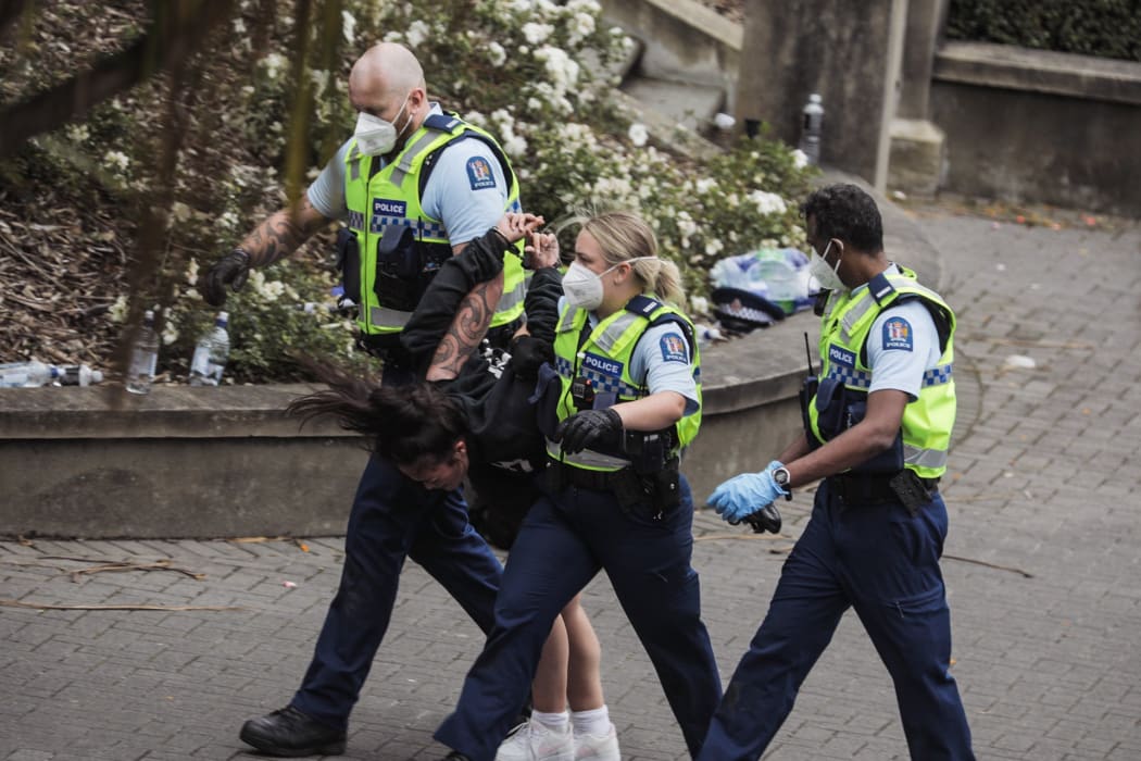 Police with a handcuffed Covid-19 protester on 10 February 2022.