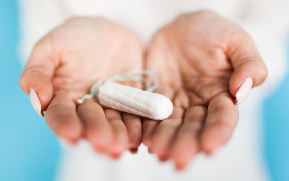 Woman holding a tampon, blue background