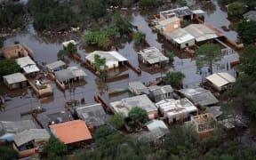 An aerial view shows a flooded area of Santa Rita neighborhood in the city of Guaiba, Rio Grande do Sul state, Brazil, on May 20, 2024. More than 600,000 people have been displaced by the heavy rain, flooding and mudslides that have ravaged the south of the state of Rio Grande do Sul for around two weeks. (Photo by Anselmo Cunha / AFP)