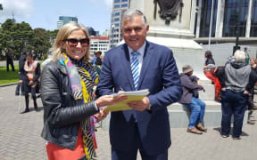 Samantha Lenik presents petition to MP Mark Mitchell seeking more funding for medicines for rare diseases.