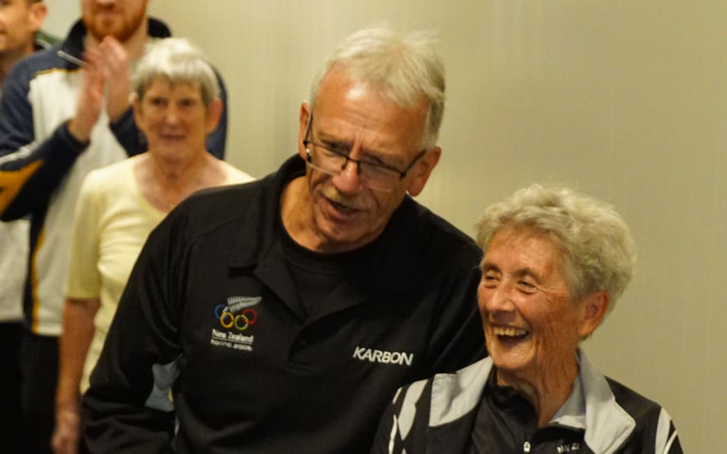 Picture depicts two people standing and laughing together.