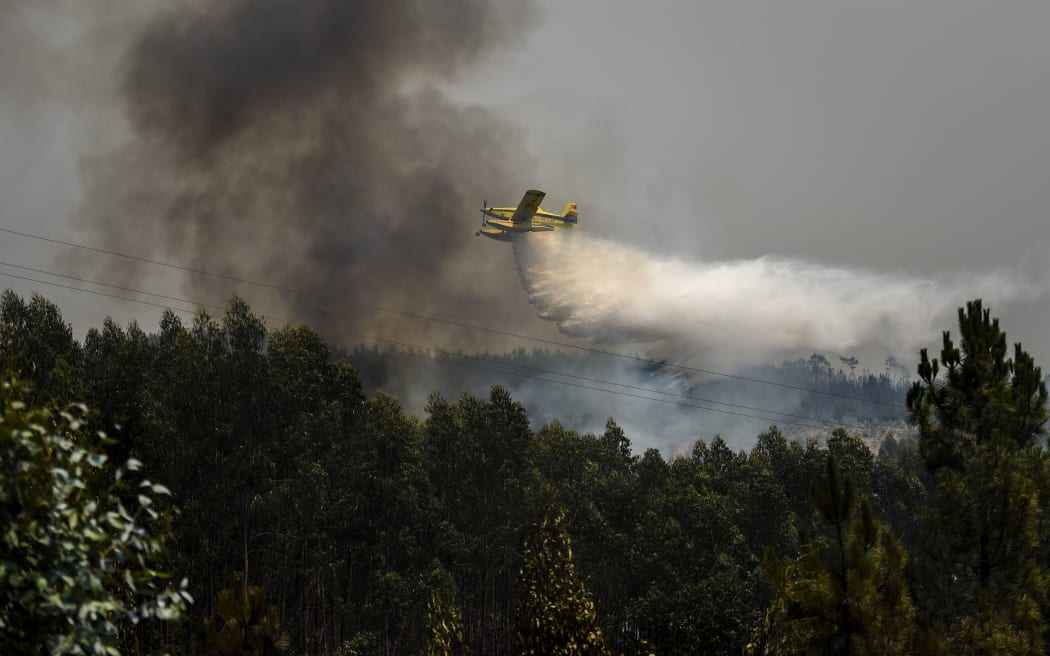 A firefighter plane drops water over a wildfire in Amendoa, Macao, in central Portugal on July 21, 2019.