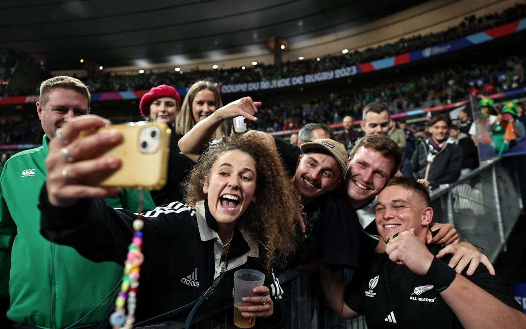 New Zealand loosehead prop Ethan de Groot (R) poses for selfie photos after winning the quarter-final Rugby World Cup 2023 match between Ireland and New Zealand at the Stade de France.