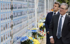 Britain's Prime Minister Keir Starmer (R), France's President Emmanuel Macron (L) visit the Wall of Heroes of the Nation, a memorial wall of fallen Ukrainian servicemen, in Kyiv.