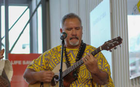 Ena Manureia plays guitar. He's on a mission to save the Mangarevan language