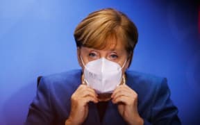 28 October 2020, Berlin: Chancellor Angela Merkel puts on her face mask at the end of a press conference in the Chancellery after a meeting with the prime ministers of the Länder on how to proceed in the corona pandemic.