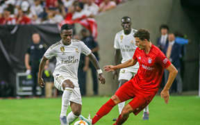 Real Madrid forward Vinicius Junior (L) and Bayern Munich defender Benjamin Pavard.