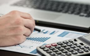 Businessman analyzing investment charts with laptop