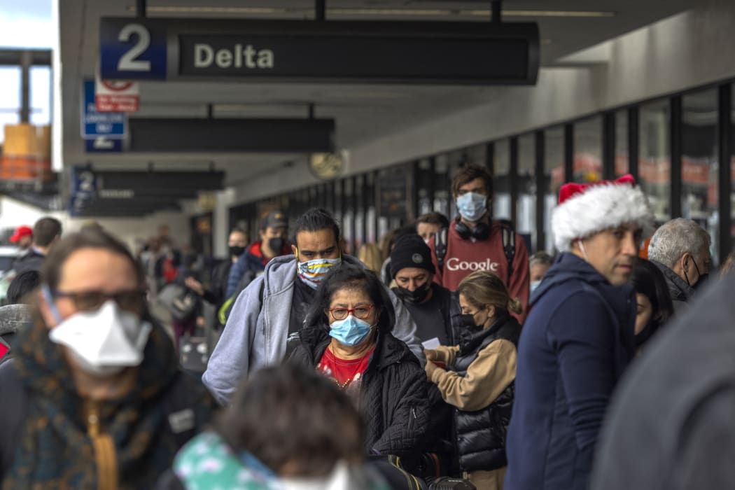 Travellers arrive at Los Angeles International Airport in Los Angeles, California, on December 23, 2021.